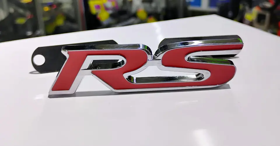 Emblema de parrilla apernado metalico modelo RS cromado con rojo 1