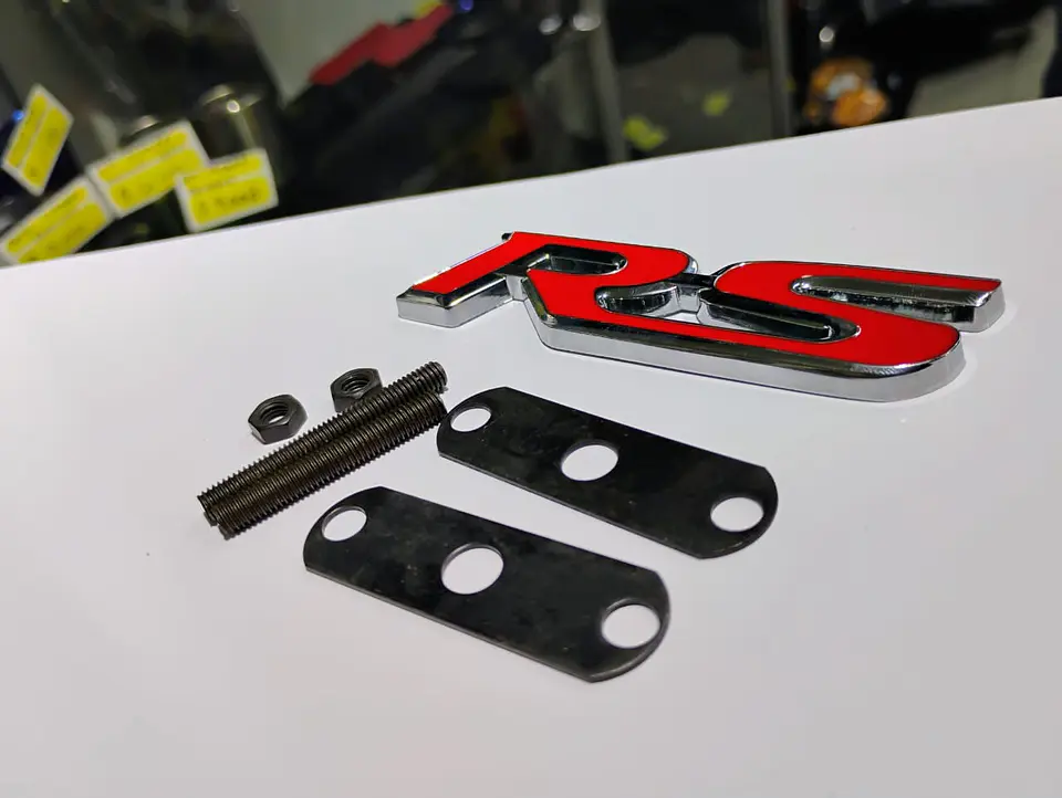 Emblema de parrilla apernado metalico modelo RS cromado con rojo 10