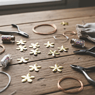 Dije flor baño de oro, 17 mm de diámetro, set de 12 unidades (por mayor)