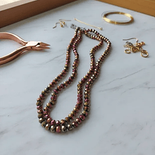 Cristal facetado de 6 mm, color fucsia y cobrizo metalico tornasol, tira de 85 cristales aprox.