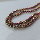 Cristal facetado de 6 mm, color fucsia y cobrizo metalico tornasol, tira de 85 cristales aprox.