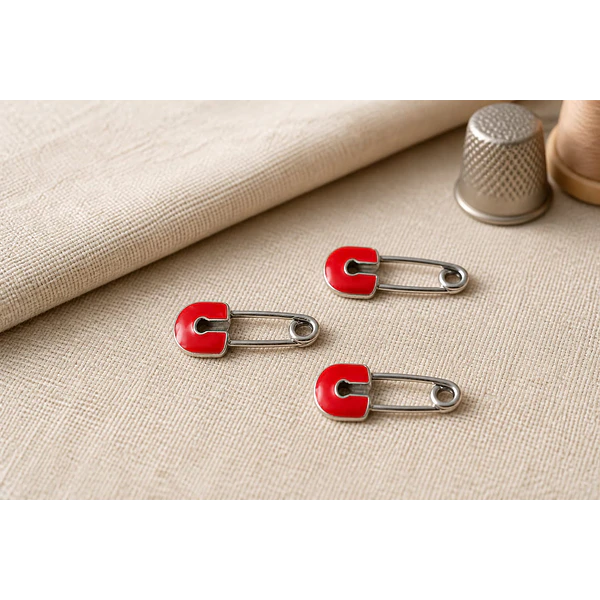Dije esmaltado, en forma de gancho con color rojo base plateado, 26 x 12 mm, por unidad