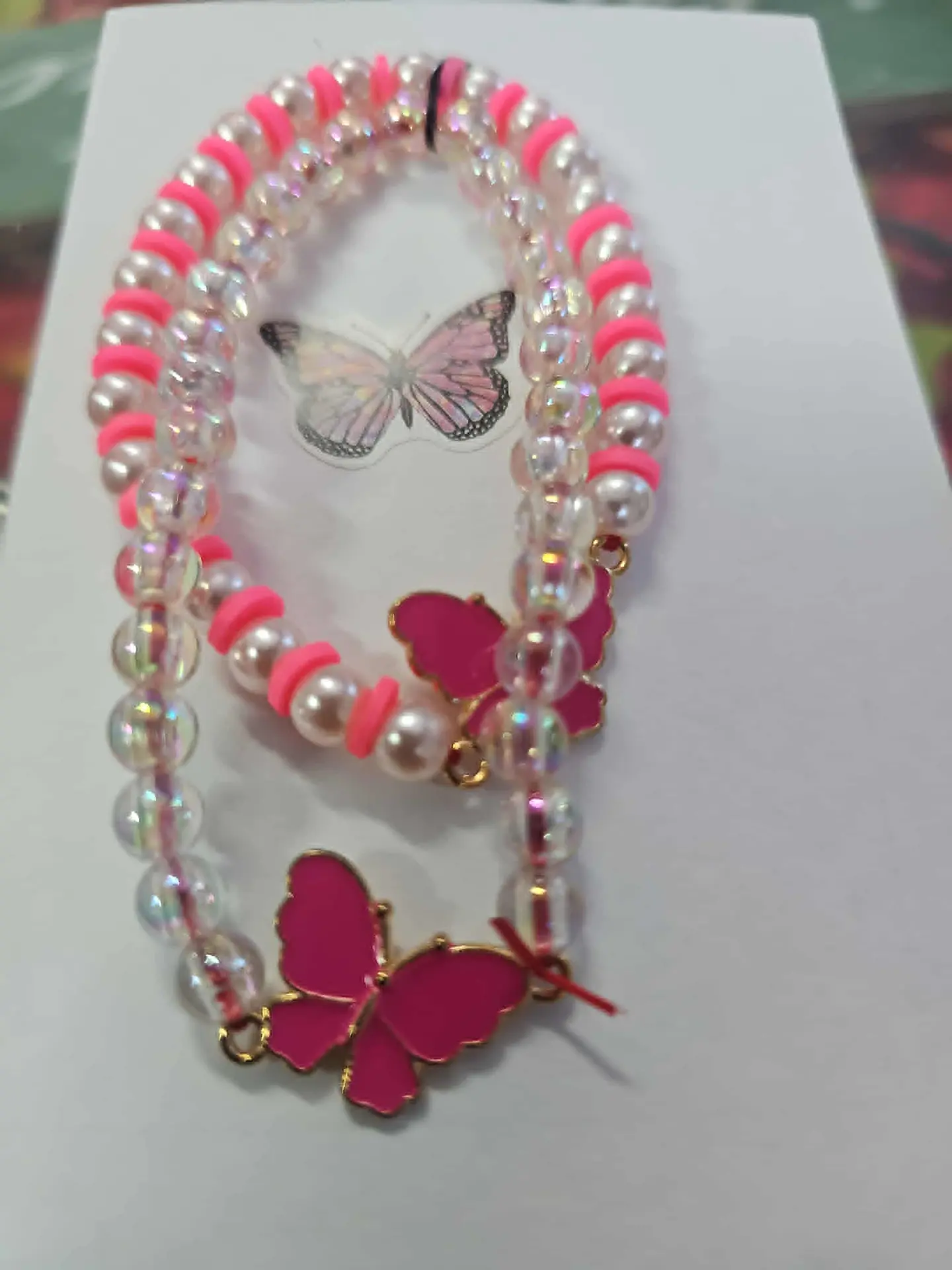 💖🦋 Pulseiras Duplas Borboleta Rosa – Amor e Alegria ✨  A Pulseira Dupla Borboleta Rosa é pura doçura e energia positiva! 🌸 Composta por pérolas, cristais e detalhes em rosa neon, ela simboliza o am 1