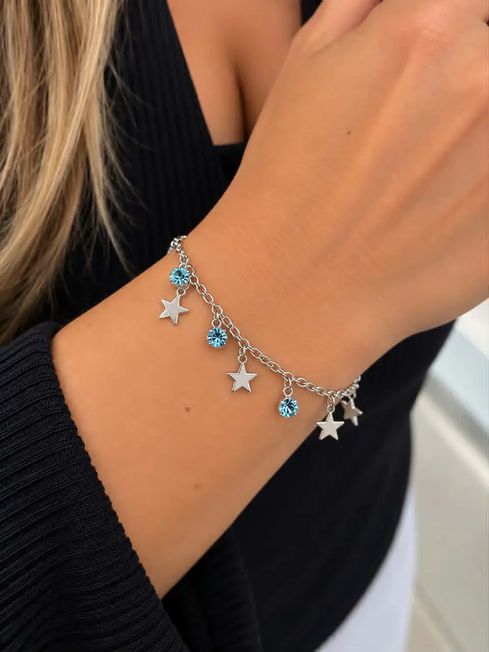 Pulseira delicada em tom prateado, com estrelinhas pendentes e pedras azuis  1