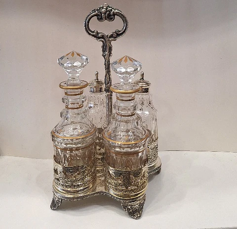 Galheteiro antigo com quatro recipientes em cristal com detalhes a ouro.