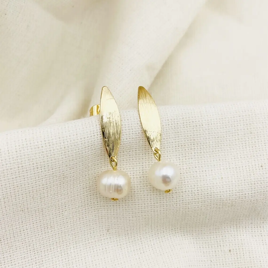 Aretes ojitos dorados con perla 1