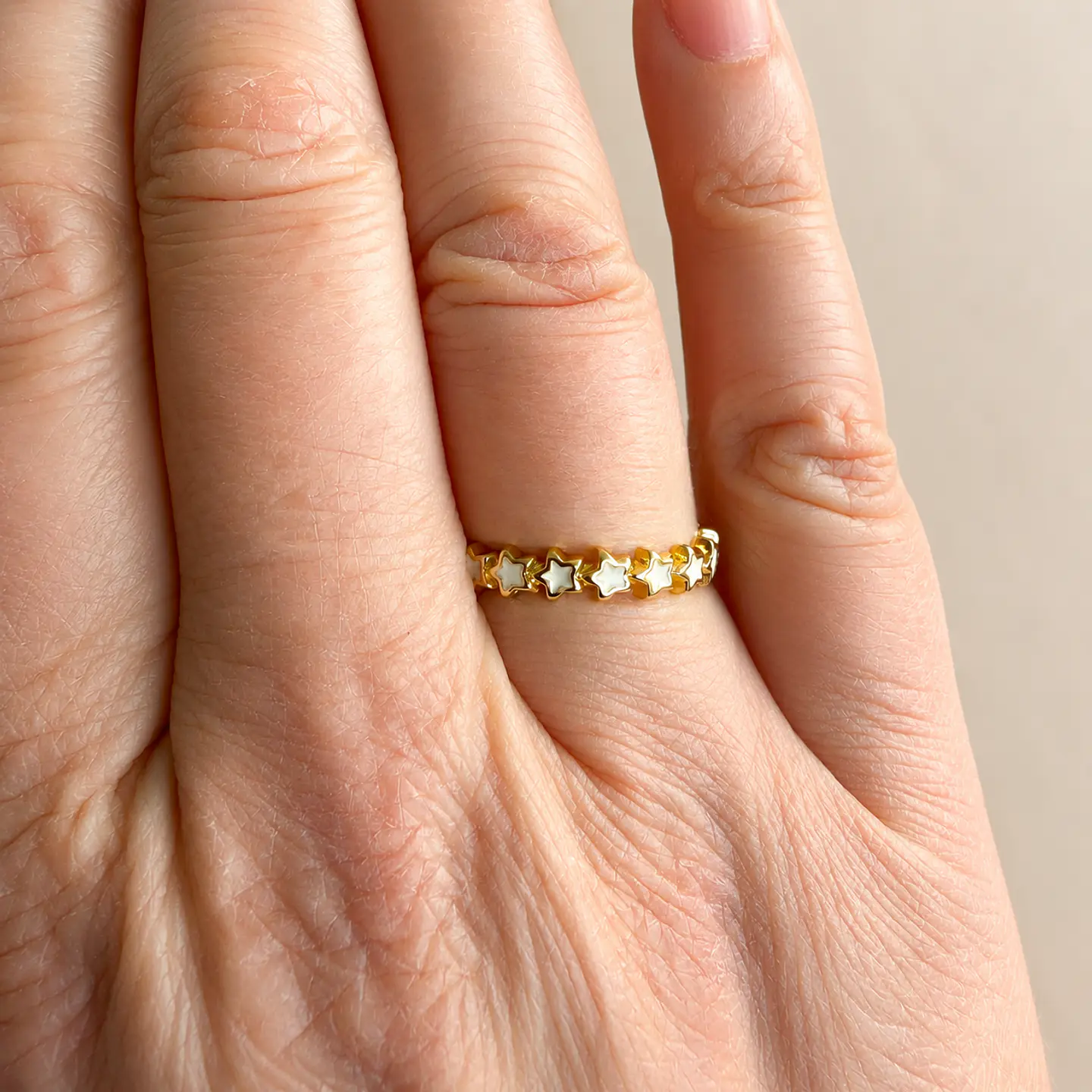 Anillo ajustable dorado con estrellas y resina puesto en la mano