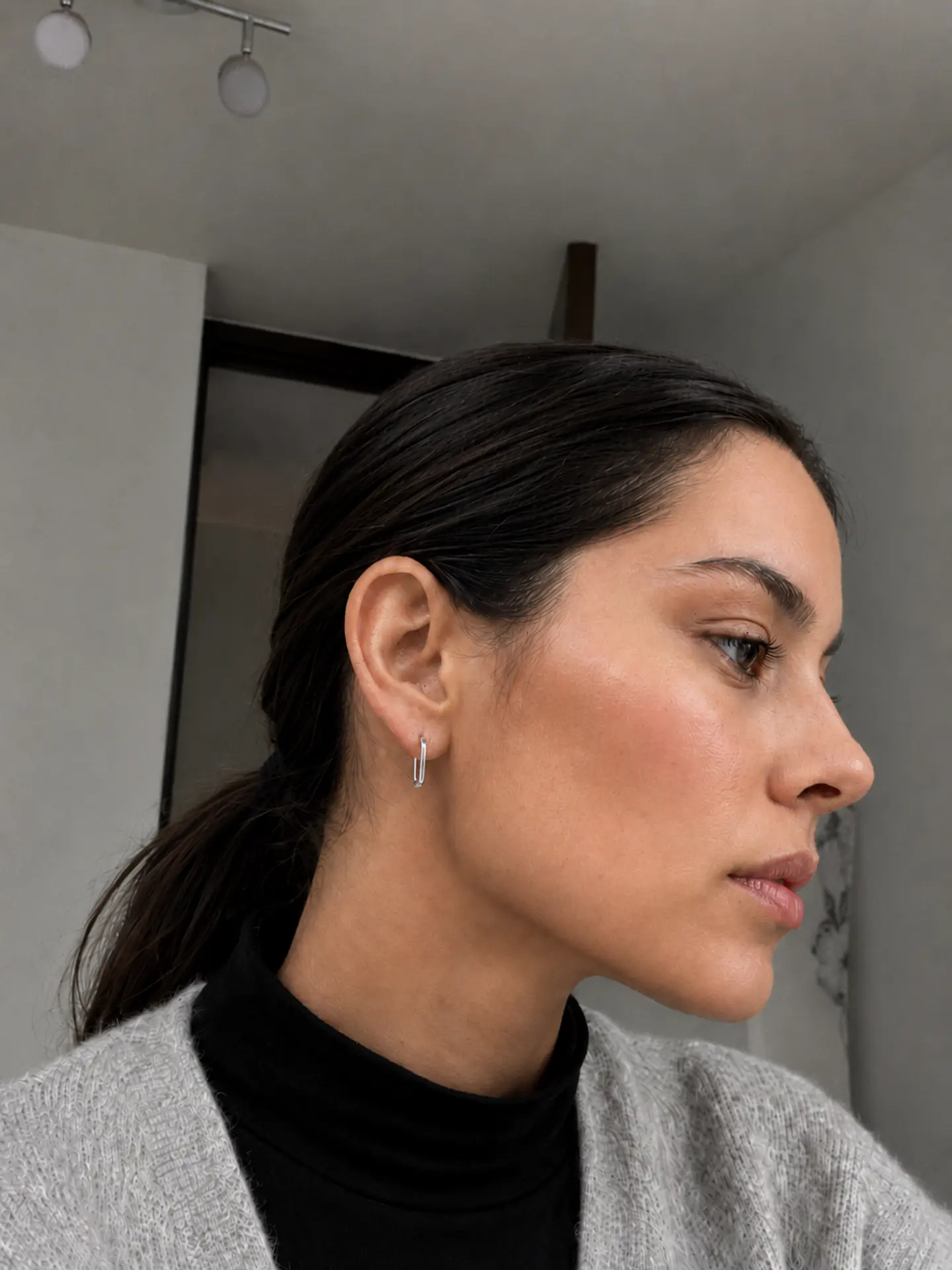 Aros rectangulares plateados combinados en un look neutro