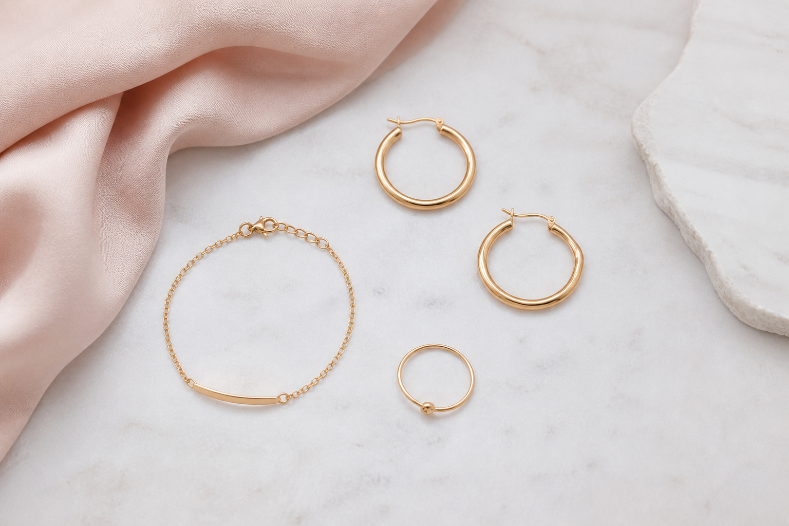 Argollas, pulsera y anillo dorados coordinados para un escote asimétrico