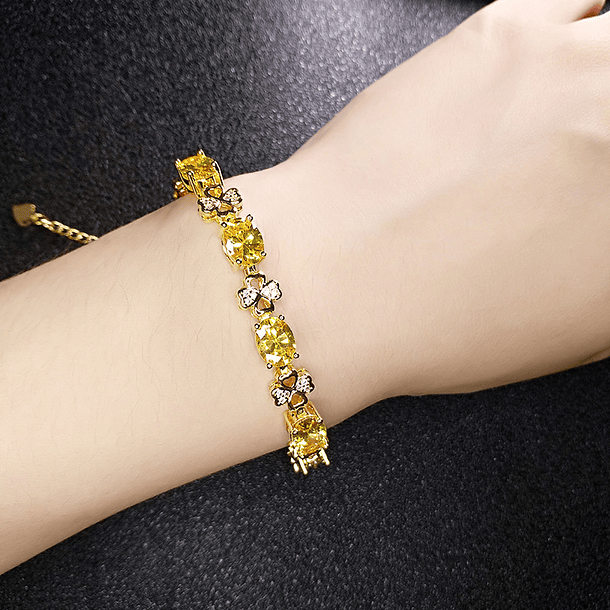 Pulsera con movimiento y diseños de trébol con zafiro amarillo de imitación corte oval y circonias blancas en cobre chapado en oro amarillo