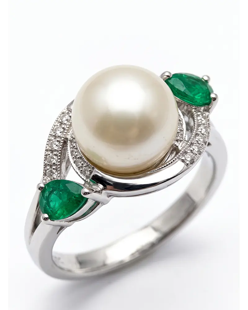 ANILLO DE PLATA RODINADA CON UNA PERLA NATURAL RODEADO DE CIRCONES Y DOS ESMERALDAS 