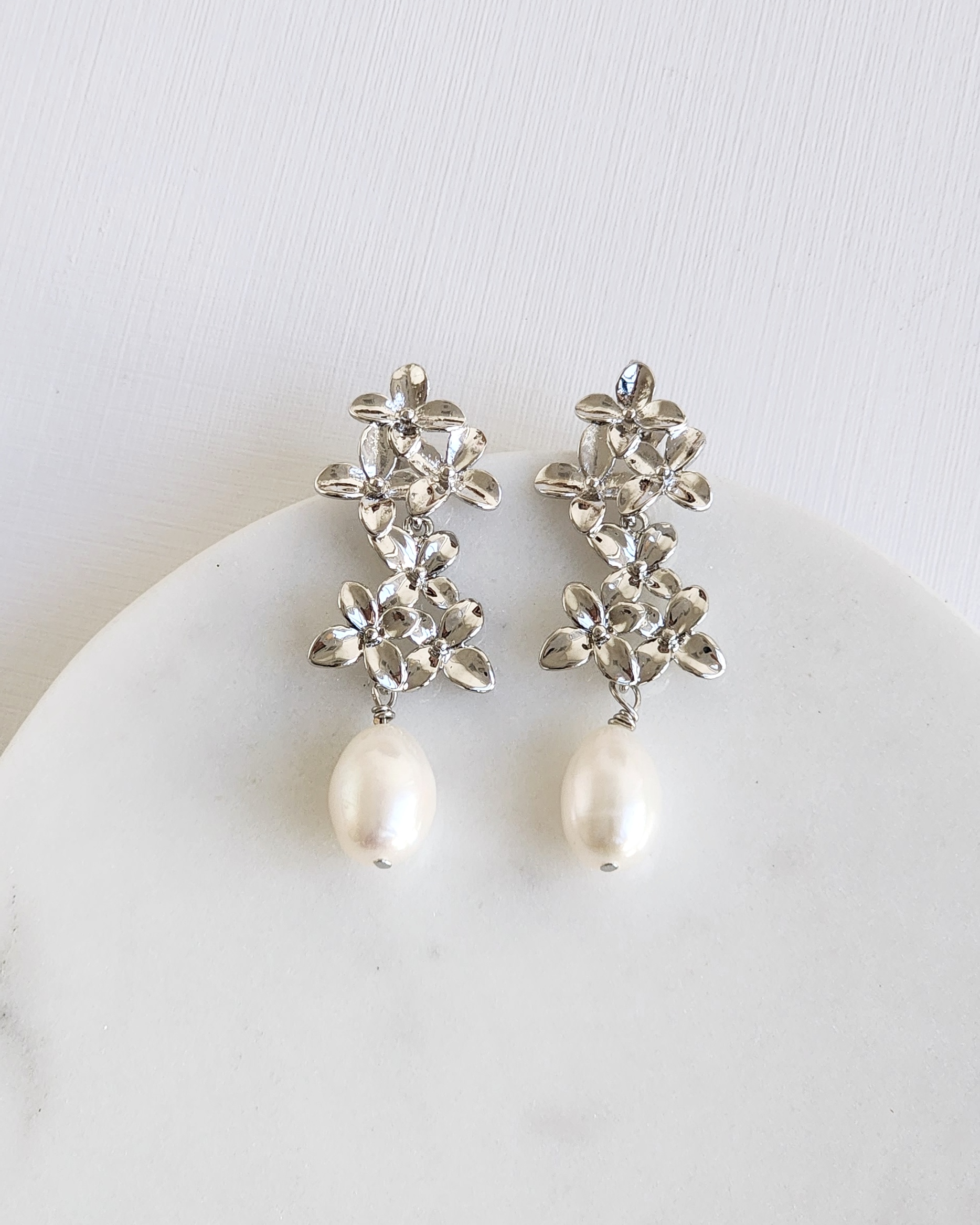 Aros doble flor plateada con perla
