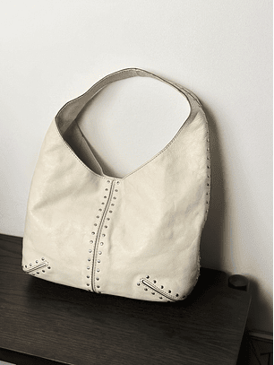 Cartera de cuero color crema con tachas