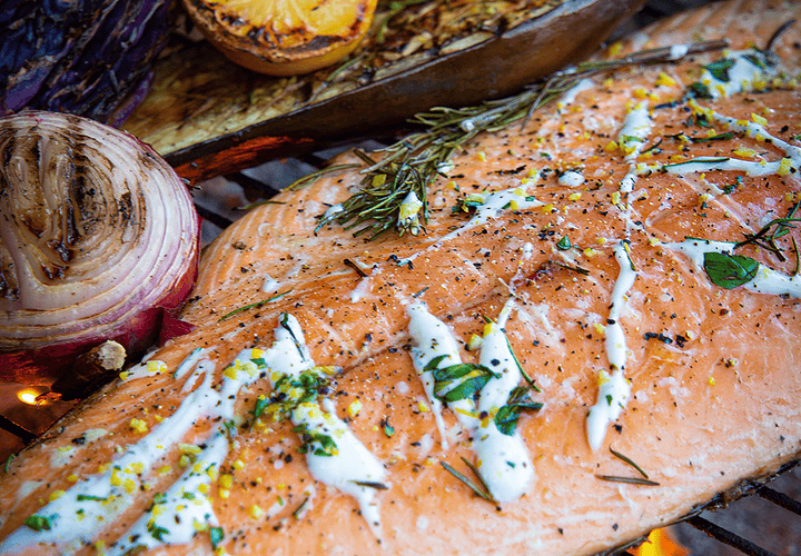 Filete de salmón con piel a la parrilla con hierbas frescas, ralladura de limón y salsa de yogur.