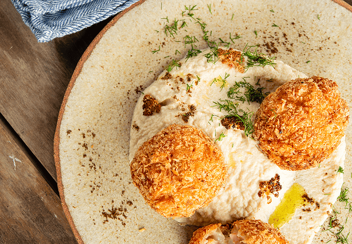 Croquetas de salmón ahumado sobre puré de coliflor asada