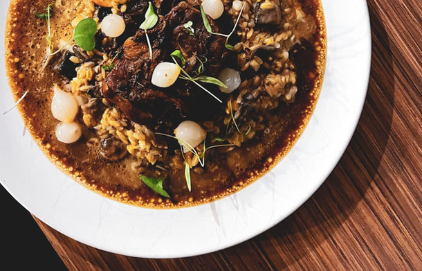 Guiso de arroz con carne y longaniza de emú, con variedad verduras y hortalizas, con crema trufada