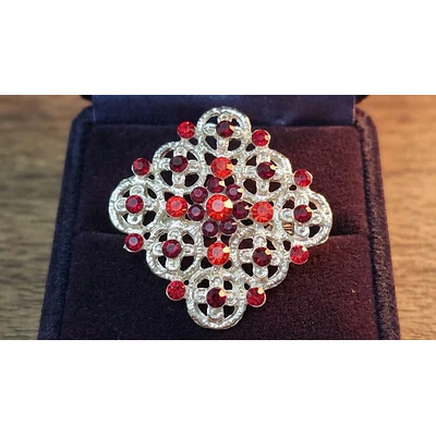 Broche geométrico de 3.5 cm con gemas rojas, granates y metal plateado