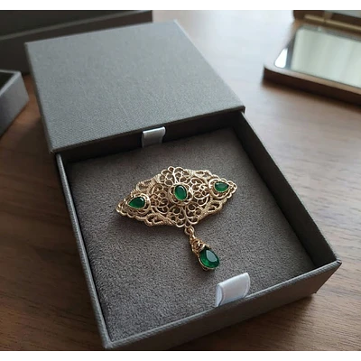 Broche Regional Dorado con Gemas Verdes  Elegancia Tradicional