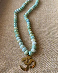 Collar de Cristales Facetados Verde Agua con Símbolo Om: Claridad y Paz 