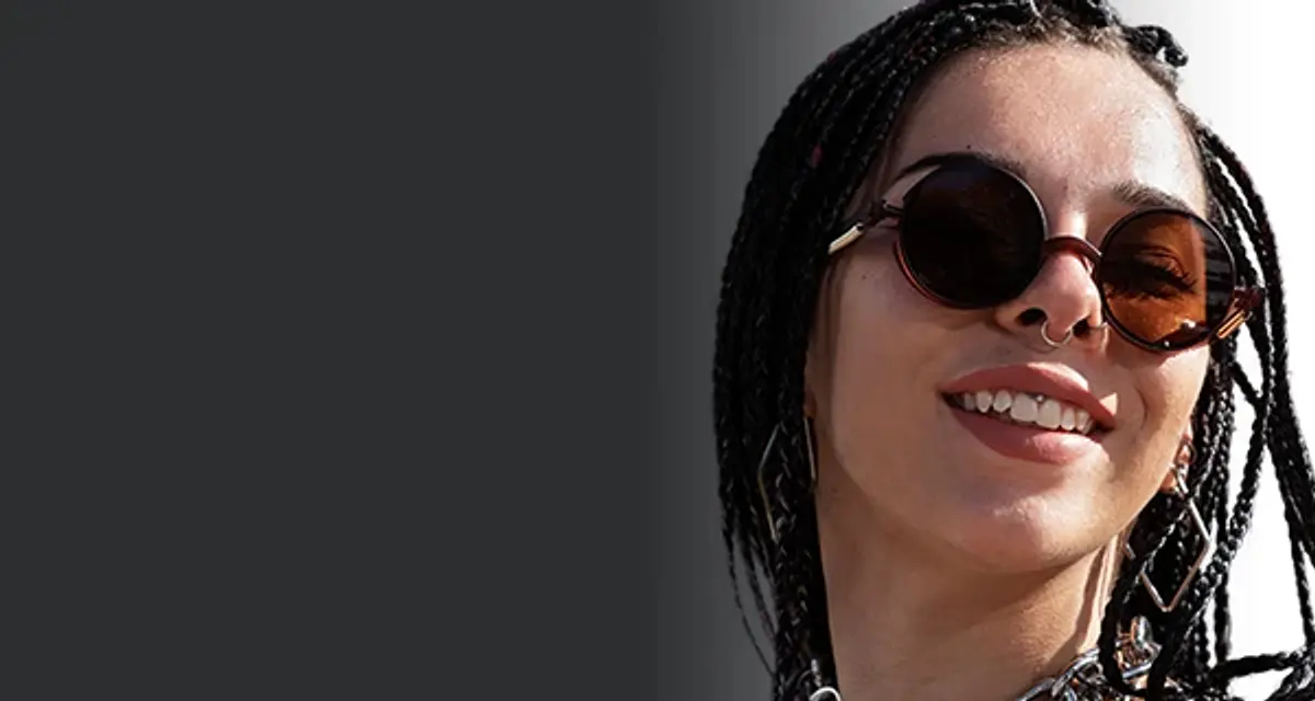Chica con trenzas luciendo lentes de sol de moda con protección UV.