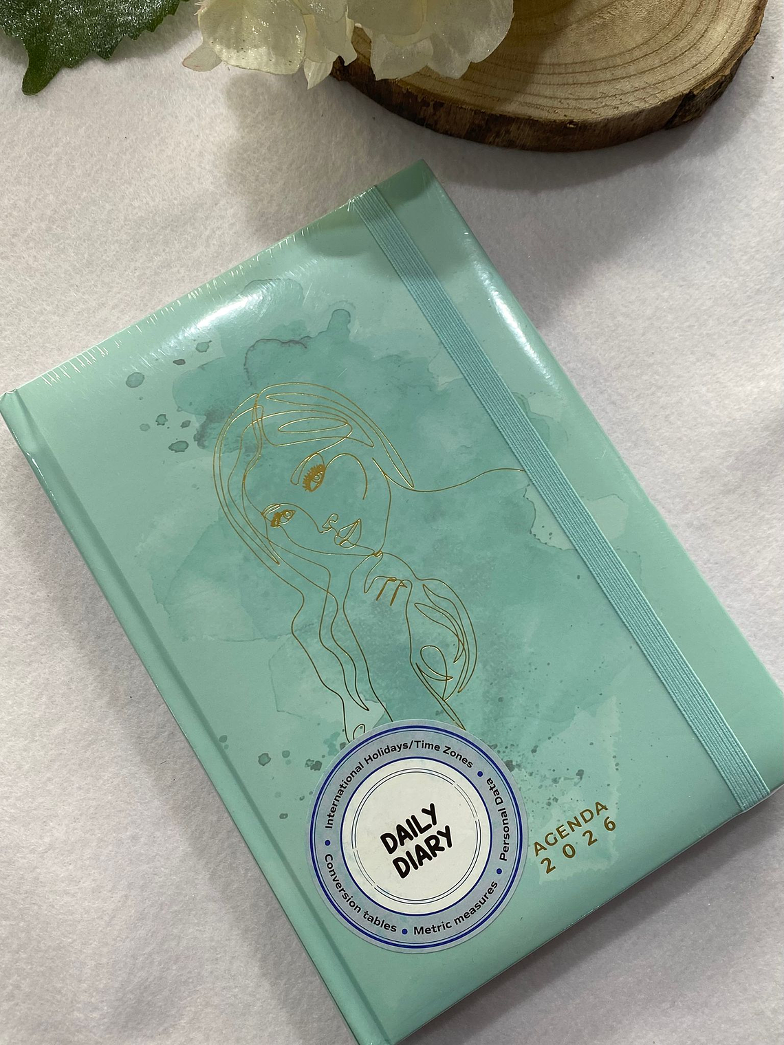 Agenda verde água com rosto em dourado 2026 1