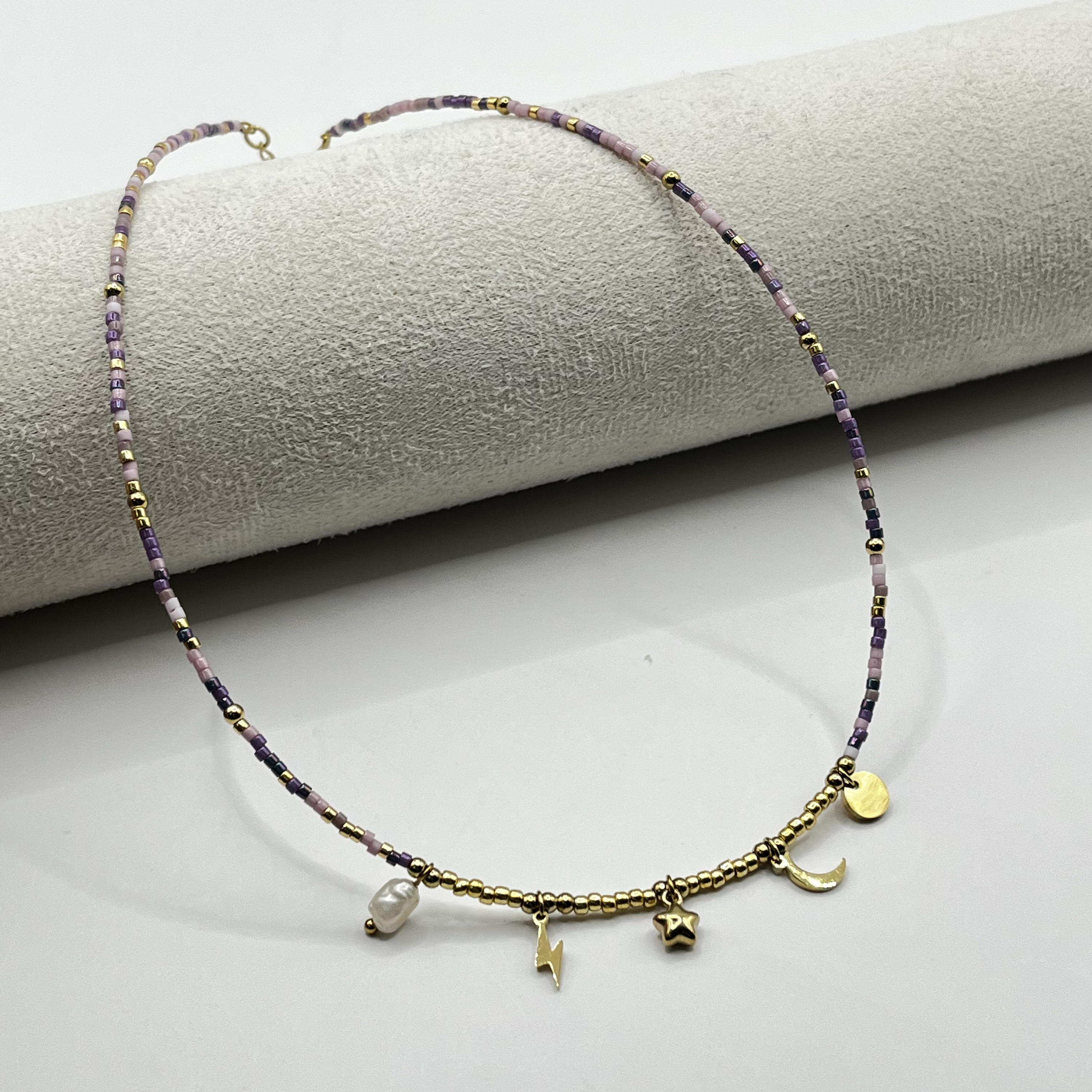 Choker de acero quirúrgico con mostacillas lila y dijes dorados 1