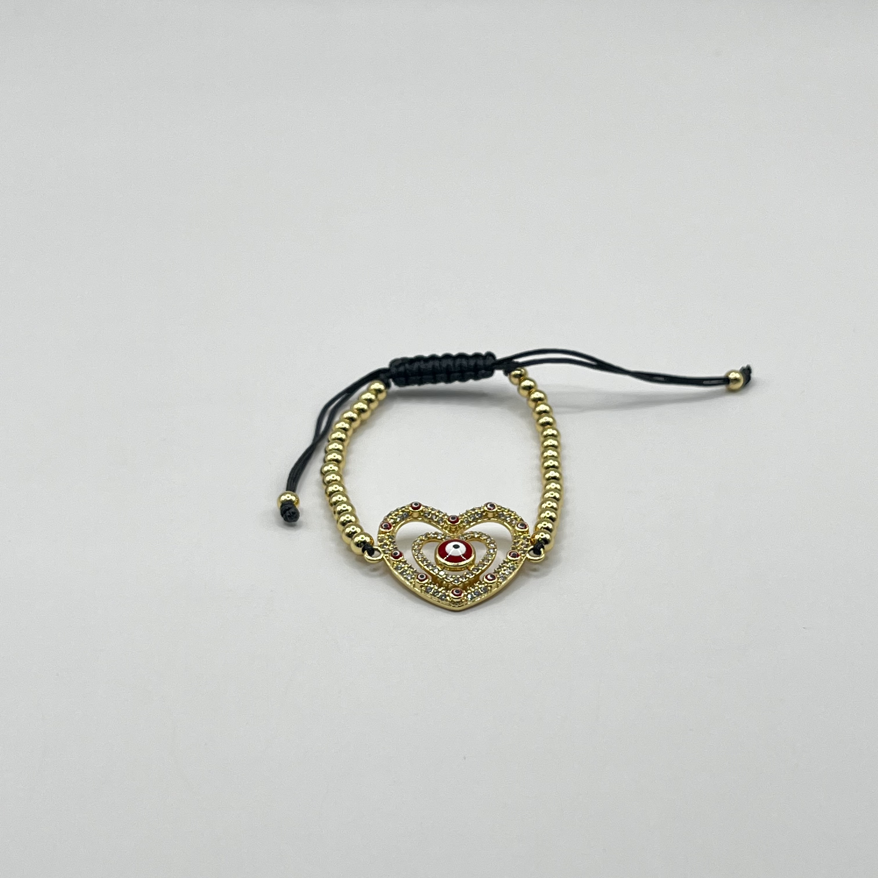 Pulsera de acero quirúrgico dorada con corazón y ojo místico ajustable 1