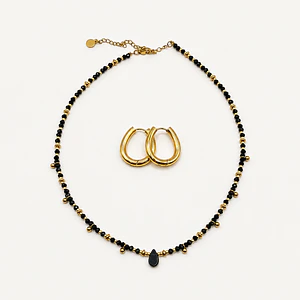 Conjunto de acero quirúrgico con choker de cristales negros y argollas doradas
