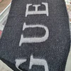MAXI BUFANDA GUESS NEGRA Y GRIS