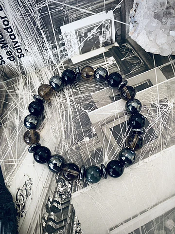 Pulsera masculina creada con Ónix negro, Hematitas, Cuarzo Ahumado y un Ojo de Halcón como piedra central.