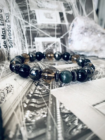 Pulsera masculina creada con Ónix negro, Hematitas, Cuarzo Ahumado y un Ojo de Halcón como piedra central.