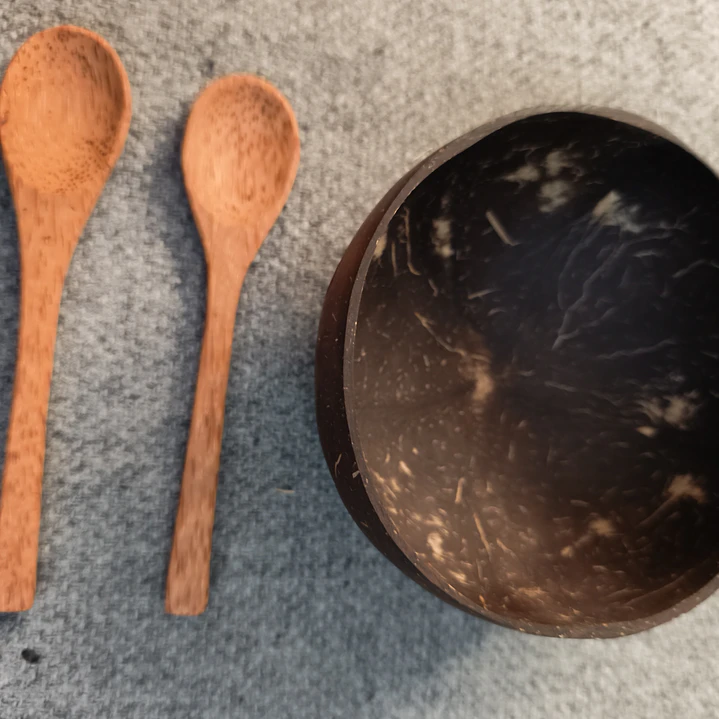 Una colección de cuatro artículos: dos cuencos de coco y dos cucharas de madera 3