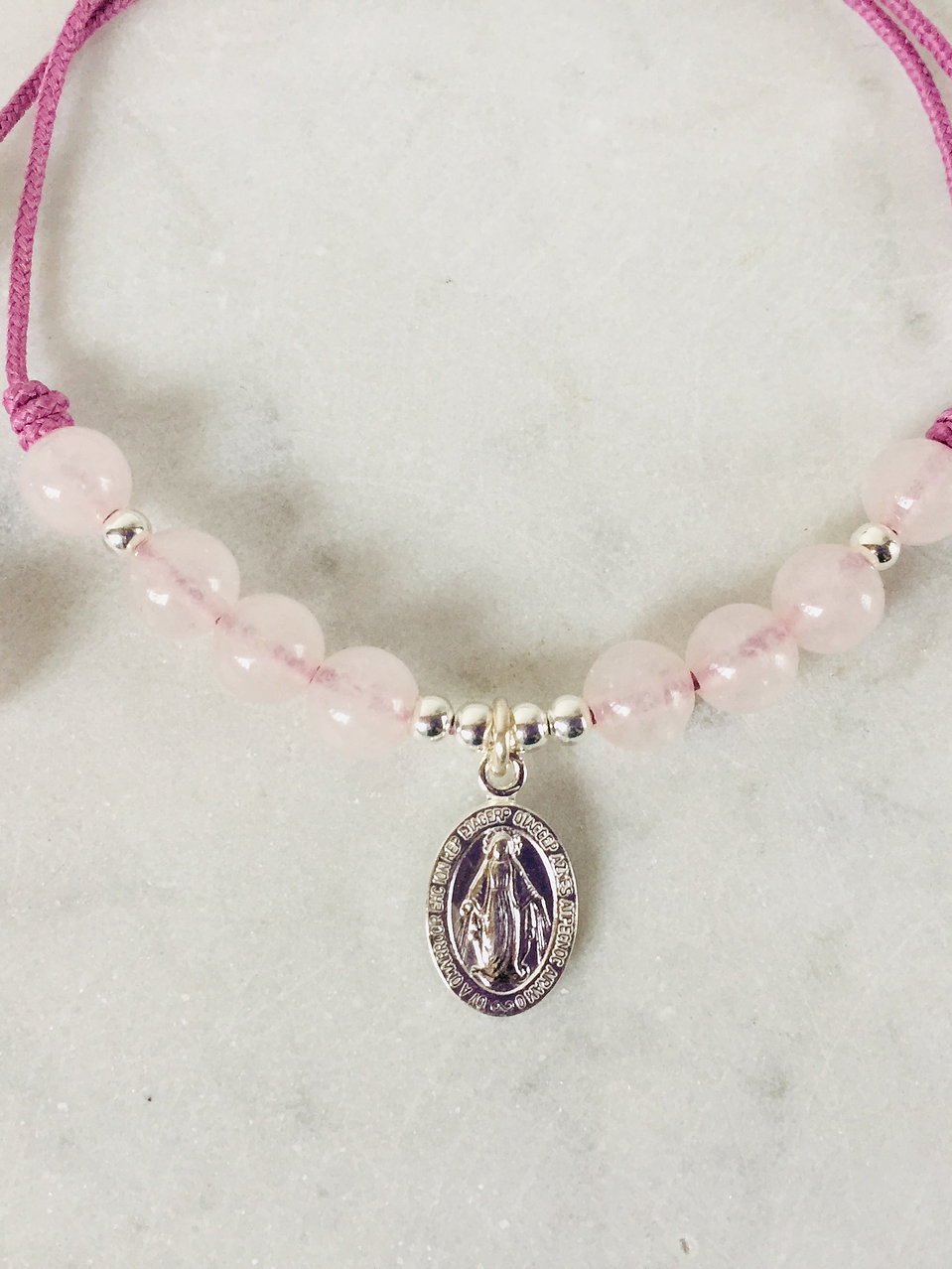 Pulsera de hilo regulable con piedras cuarzo rosado y medallita de la virgen de los rayos 1