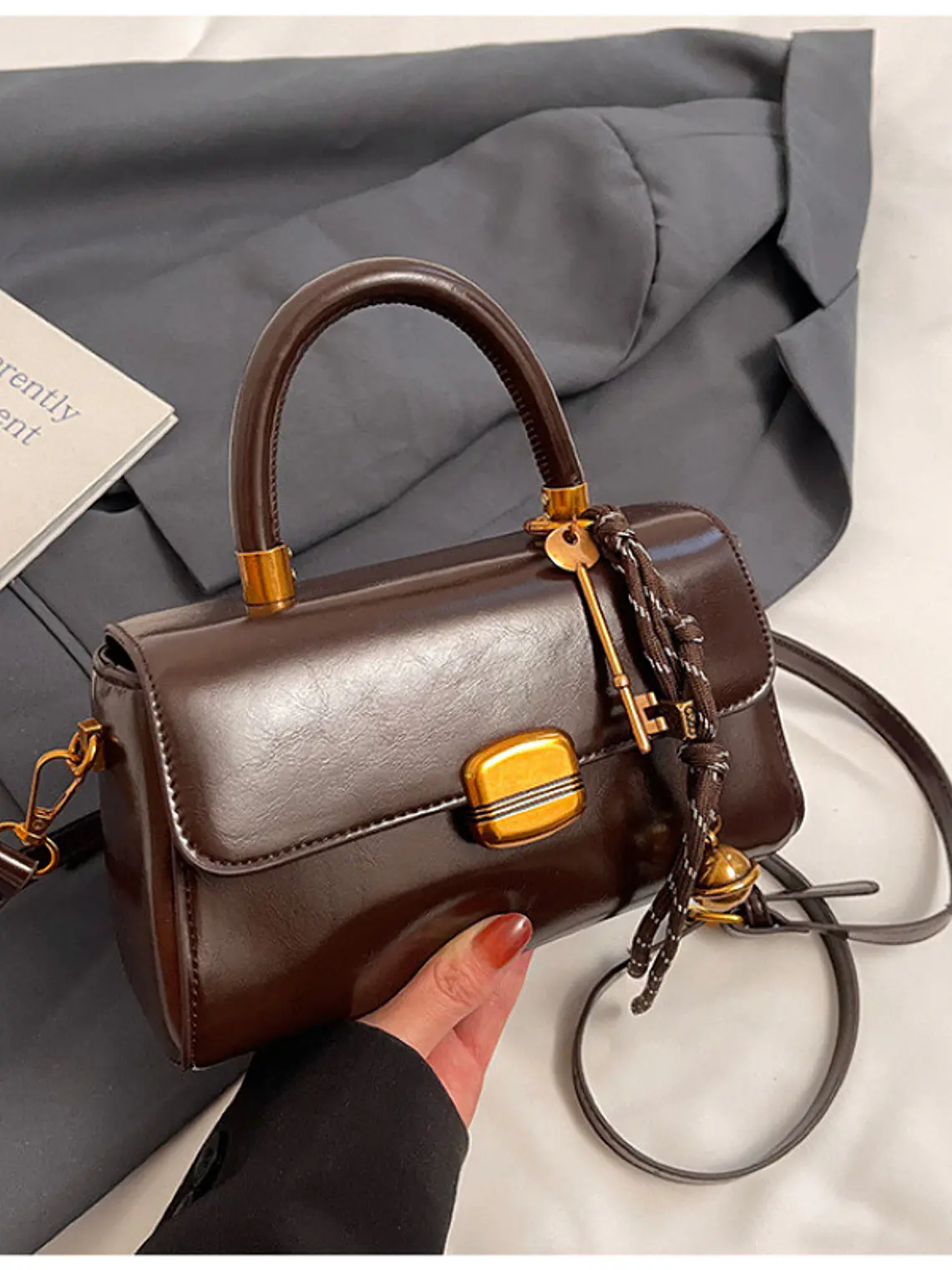 Bolso baguette con cierre de solapa y colgante decorativo — estilo retro urbano 1