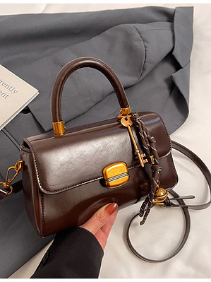 Bolso baguette con cierre de solapa y colgante decorativo — estilo retro urbano