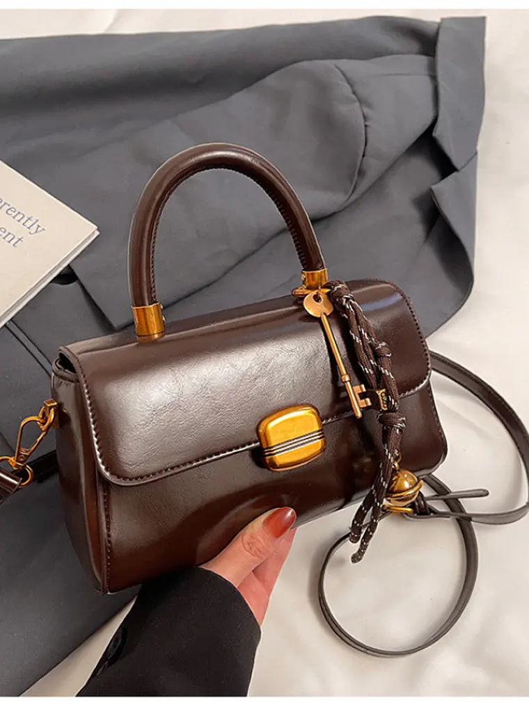 Bolso baguette con cierre de solapa y colgante decorativo — estilo retro urbano 1