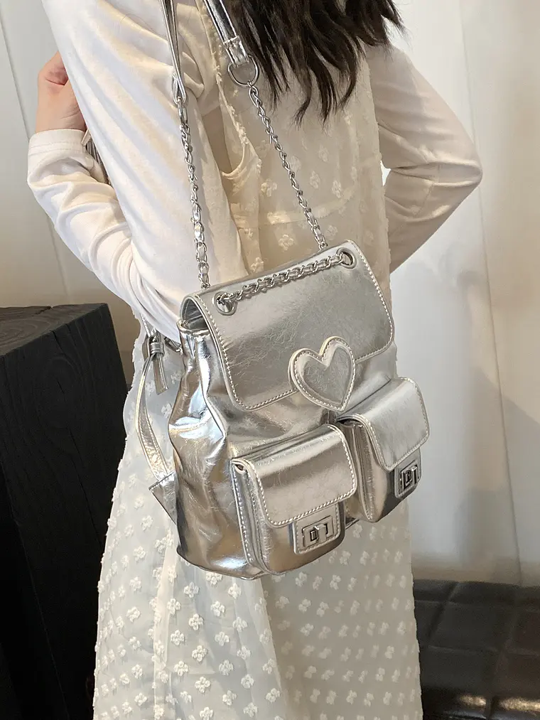 Mochila plateada con cadena, bolsillos frontales y detalle corazón 7