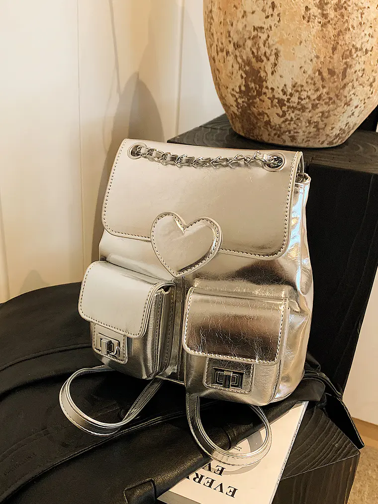 Mochila plateada con cadena, bolsillos frontales y detalle corazón 1