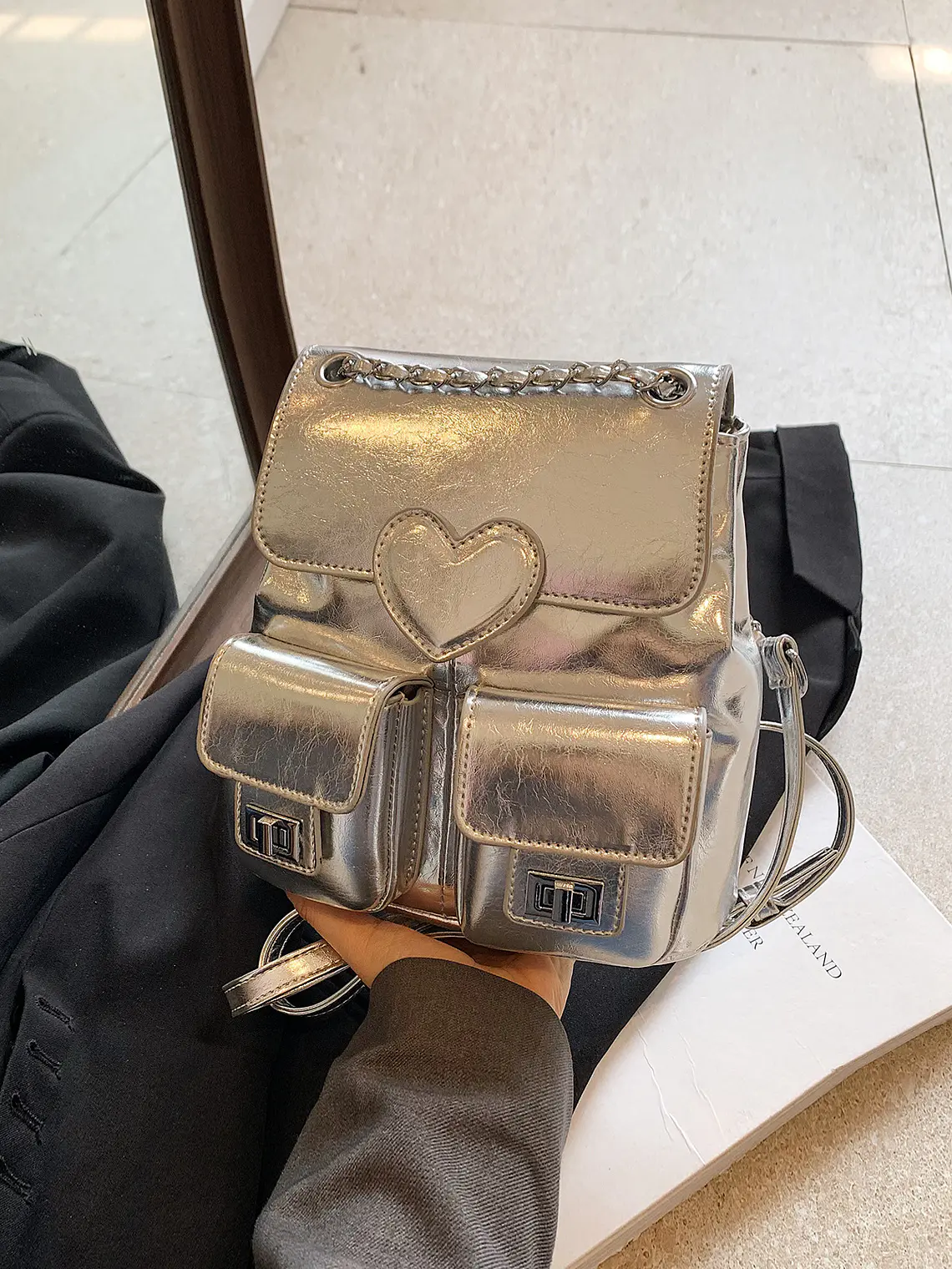 Mochila plateada con cadena, bolsillos frontales y detalle corazón 2