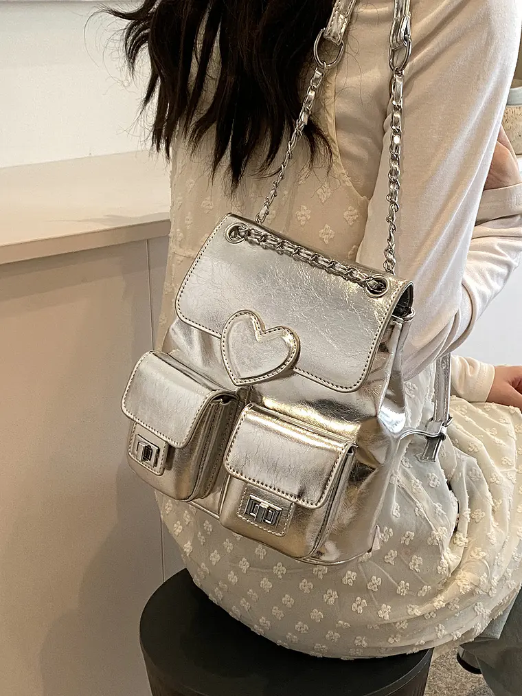 Mochila plateada con cadena, bolsillos frontales y detalle corazón 8