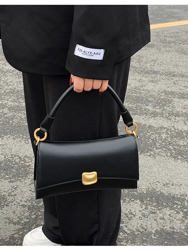 Bolso de hombro negro con cierre dorado y asa rígida — estilo urbano minimalista 1