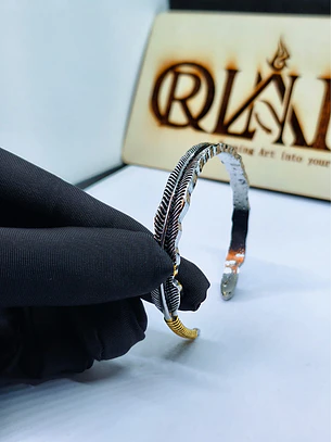 Pulseira Ajustável em Forma de Pena Prateada com Detalhe Dourado