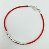 Pulseras rojas y mostacillas de plata