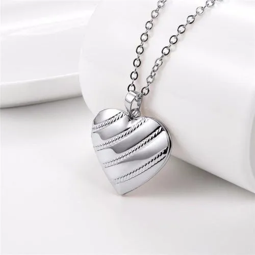 Relicario corazón con diseño tipo lasos 