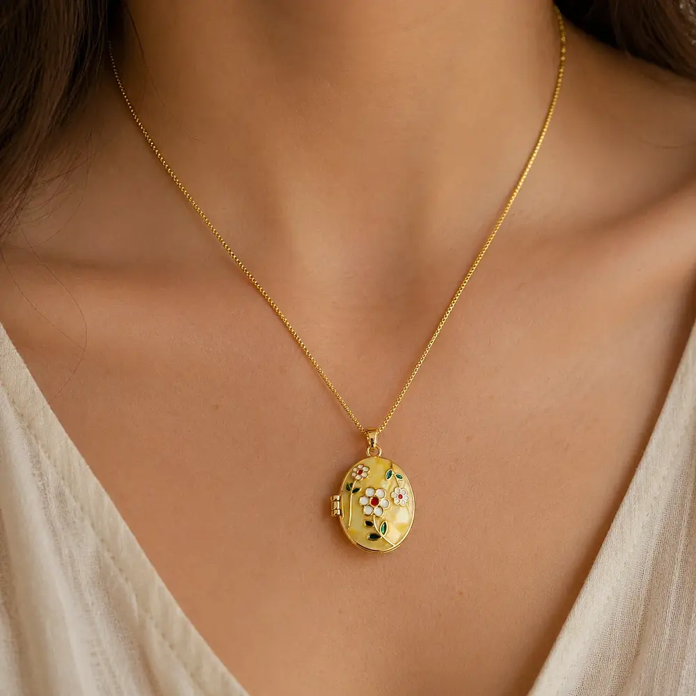 Relicario ovalado amarillo con diseño de flores blancas