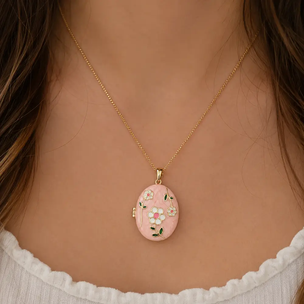 Relicario ovalado rosa con diseño de flores blancas
