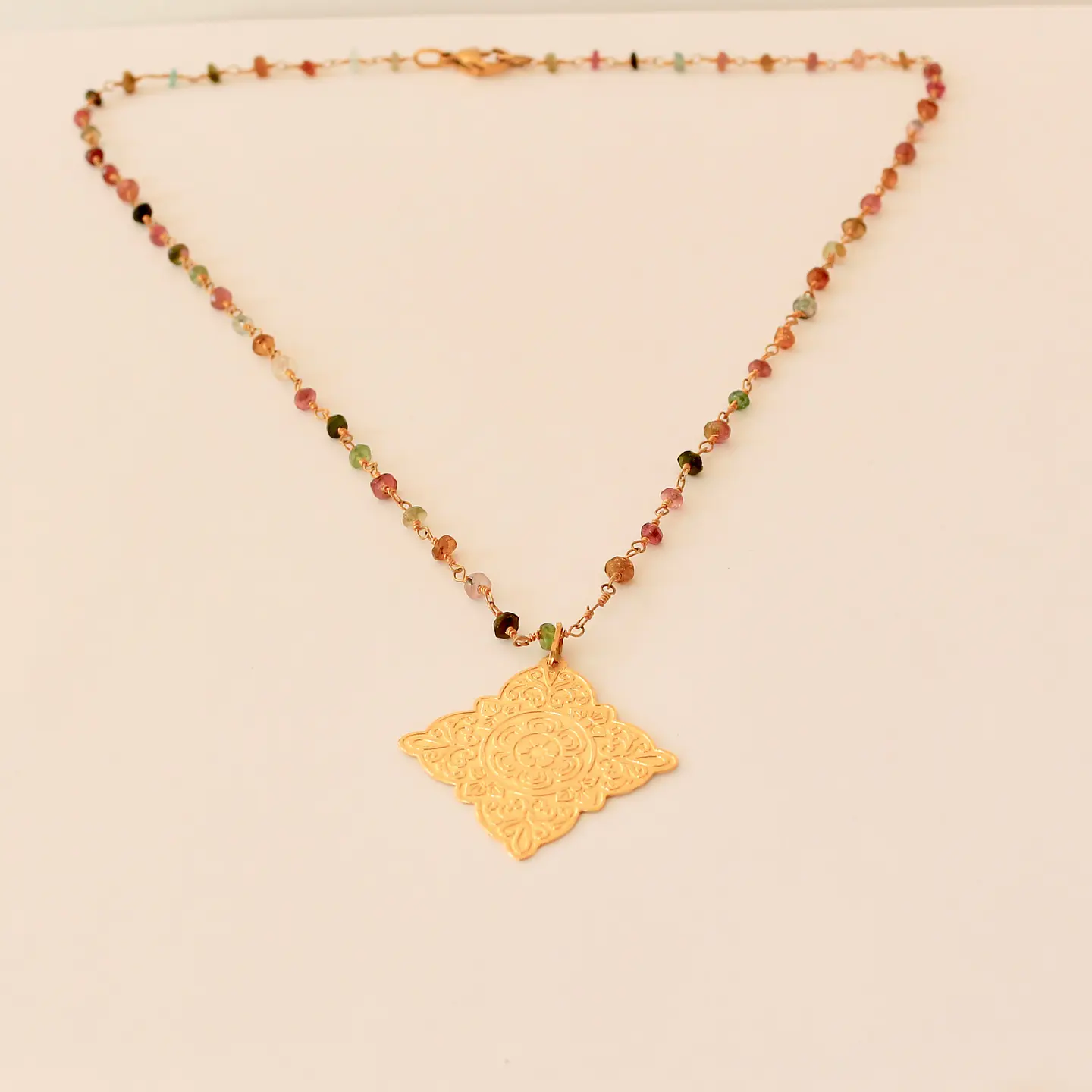 Collar bañado en oro con Turmalinas y Medallón. 1