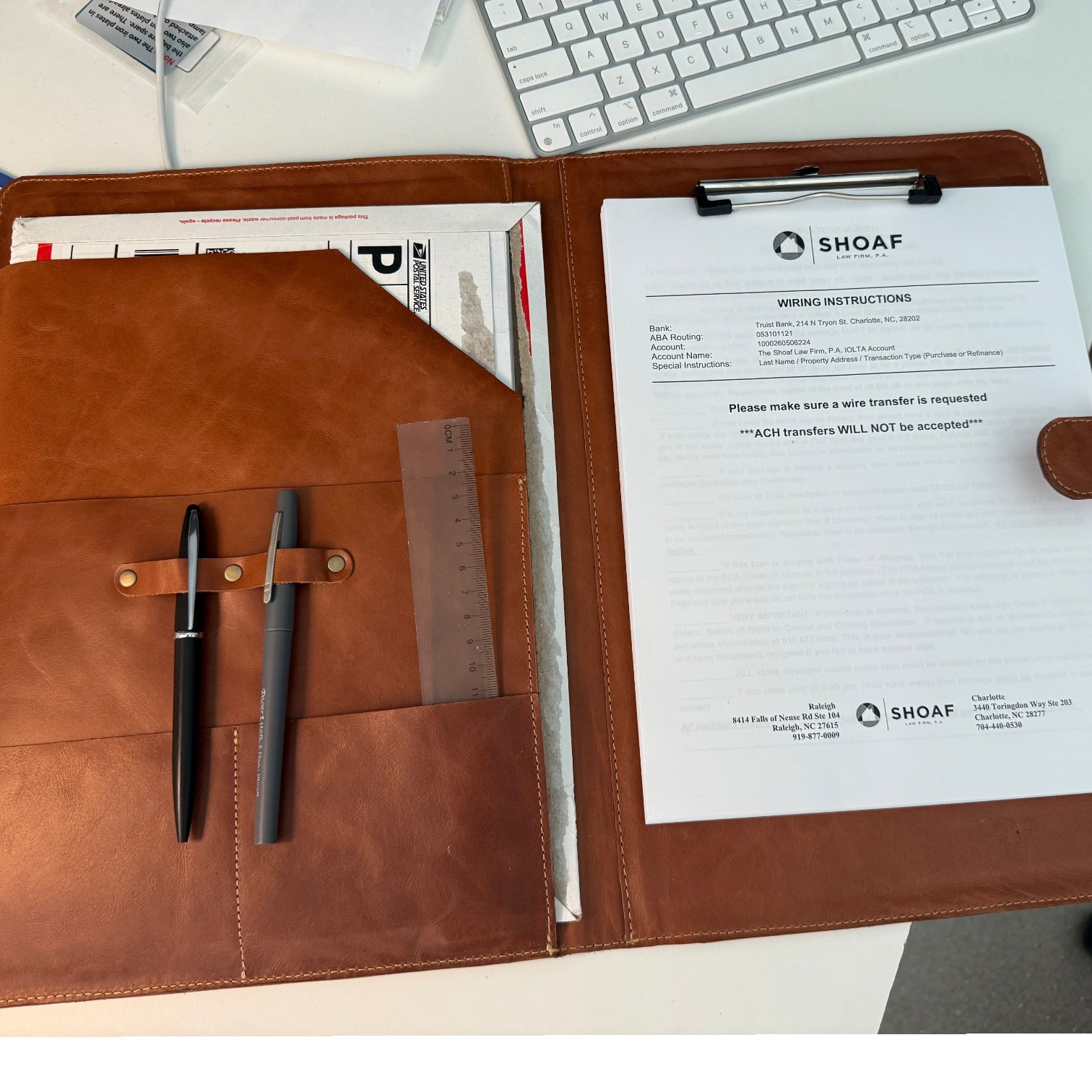 Interior de la carpeta de cuero rígida tamaño oficio abierta: clip portapapeles metálico, compartimentos, bolsillos y guardalápices